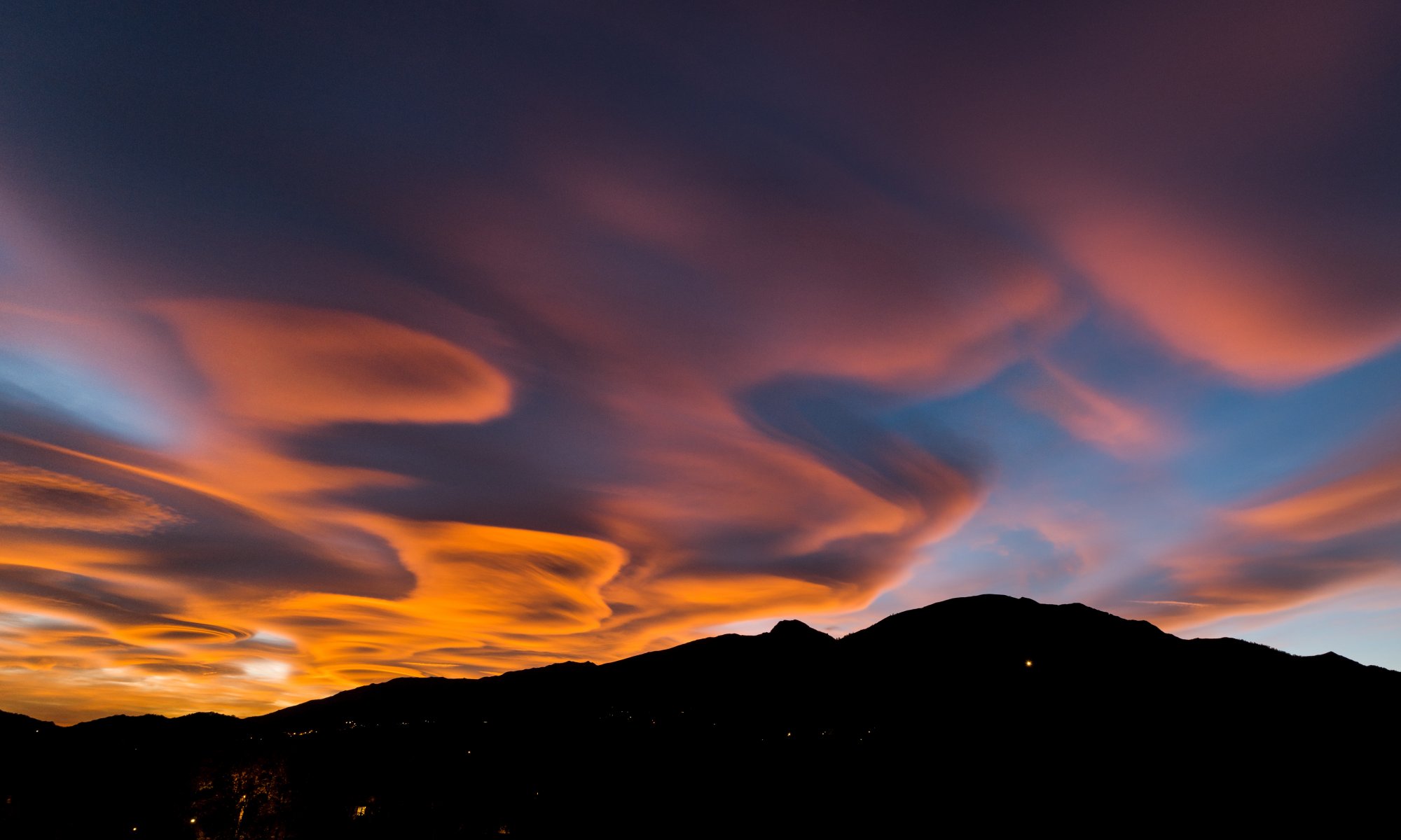 A rare Lenticularis clouds formation during the sunset over the European Alps, Biella, Piedmont, Italy - October 29, 2017 -- Adobe Stock